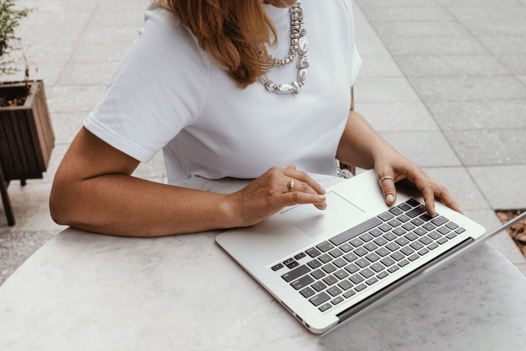 Person arbeitet an Laptop im Freien.